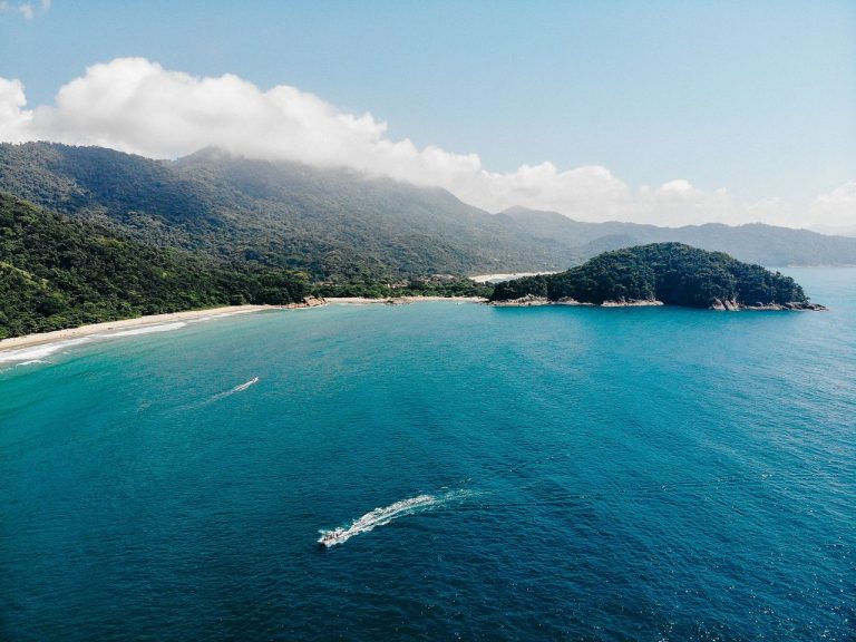 Volta da Ilha Grande revela roteiro de trekking entre praias e Mata Atlântica Vista aérea da costa verde da Ilha Grande, com praias e águas azul-turquesa